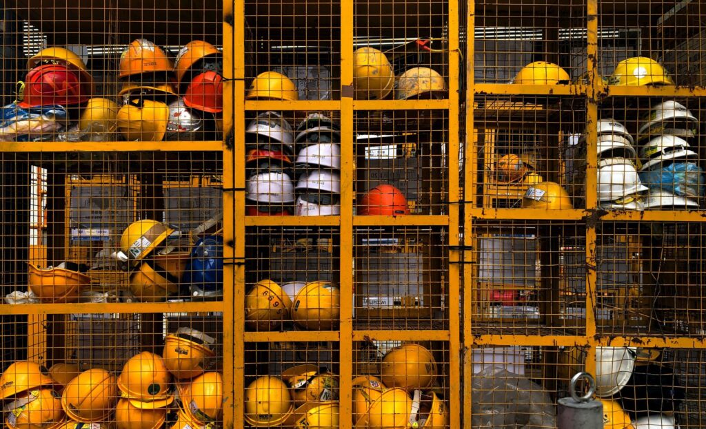 Types of hard hats in cage on construction site